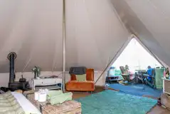 Luxury bell tent interior with furniture and complimentary touches