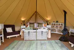 Luxury bell tent with a double bed, two futon beds, and furniture