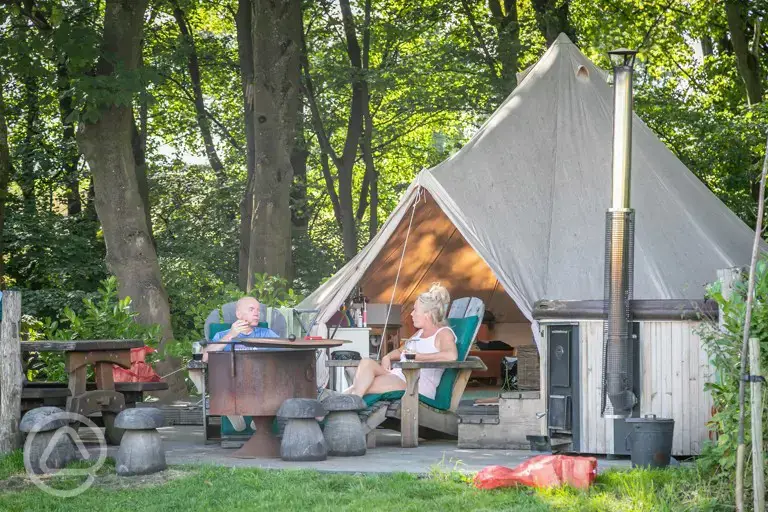 Luxury bell tents with outdoor seating, a hot tub, and fire pit at Catgill Farm