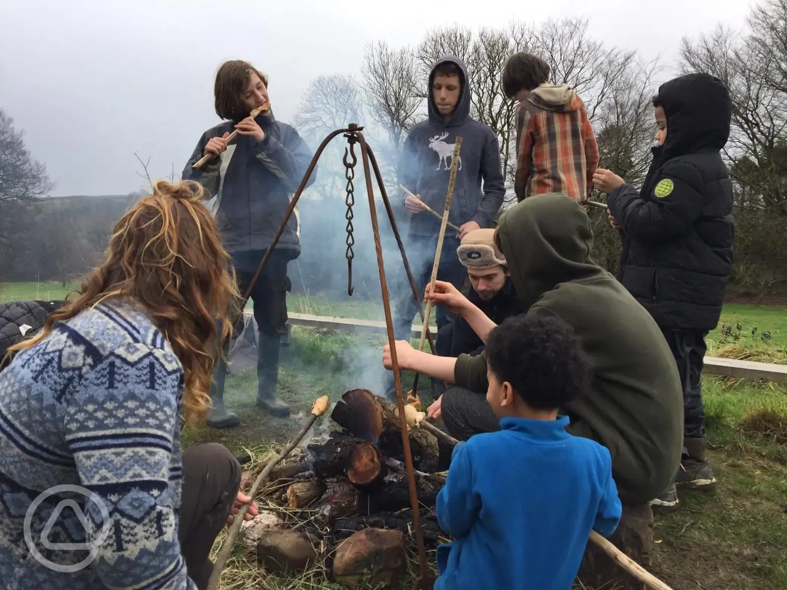 Campers round the communal fire pit