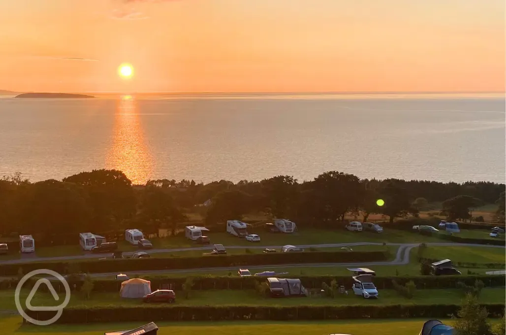 Sunset over Trwyn yr Wylfa Camping Site pitches and the sea