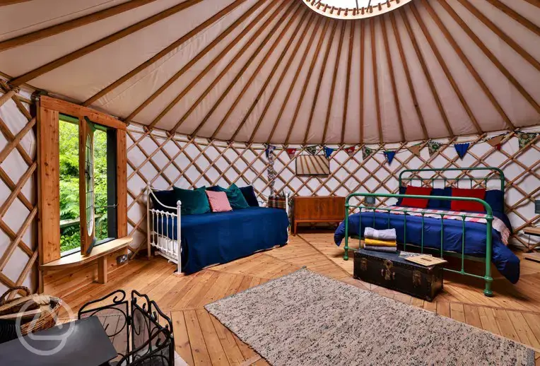 Bert the yurt interior with a king bed, two singles, and a sofa bed