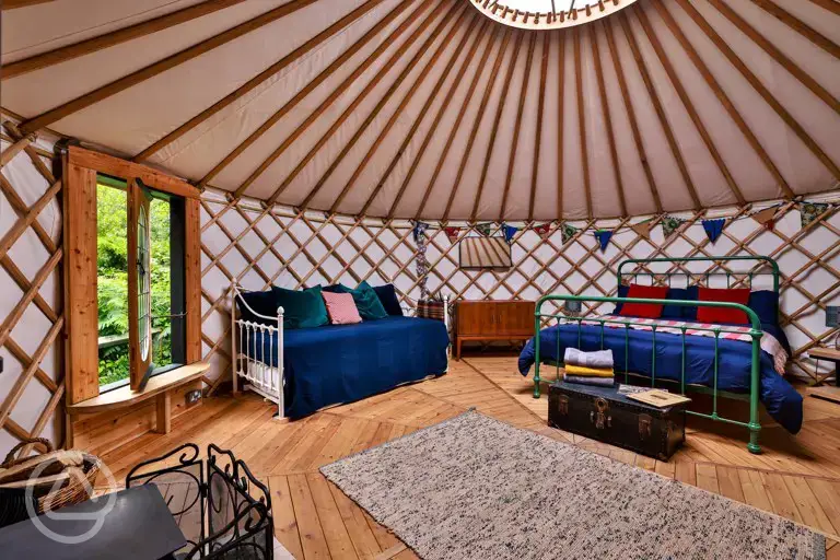 Bert the yurt interior with a king bed, two singles, and a sofa bed