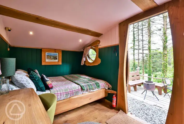 Cosy woodland cabin interior with a double bed (bedding) and furnishings