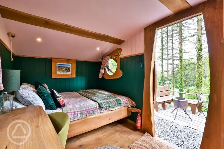 Cosy woodland cabin interior with a double bed (bedding) and furnishings