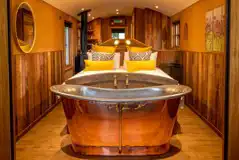 Ashwood ensuite shepherd's hut - double bed and copper bath