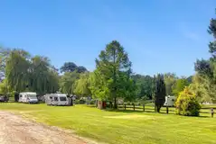 Grass touring pitches with 16 amp hook ups and small fence dividers