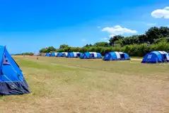Pre-erected ready tents with camp beds, chairs and a table