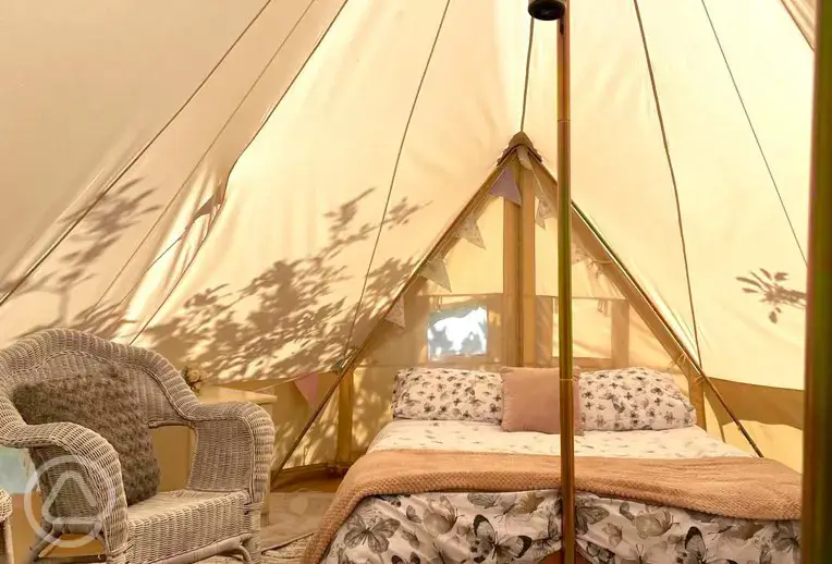Traditional bell tent interior with a double bed at The Apple Farm