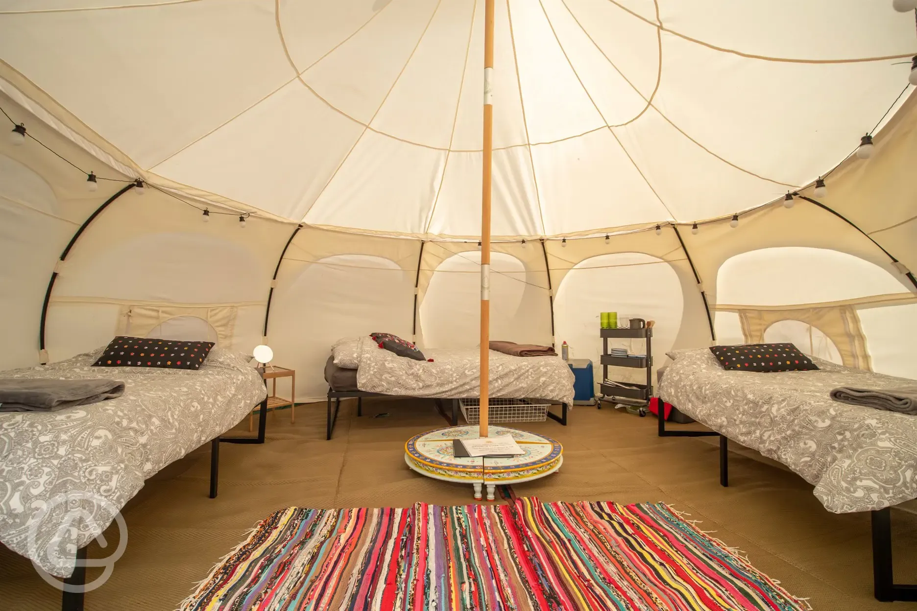 Standard bell tent interior with a double bed and two singles