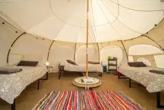 Standard bell tent interior with a double bed and two singles
