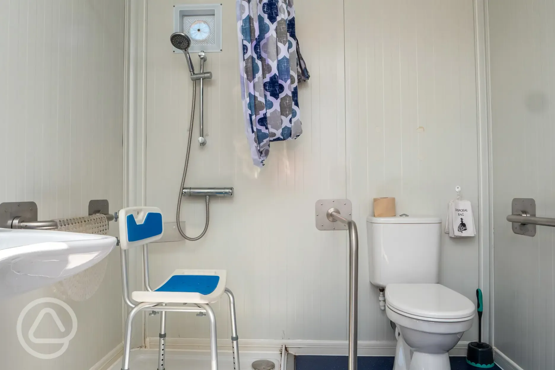Disabled wash room with a chair and grab rail