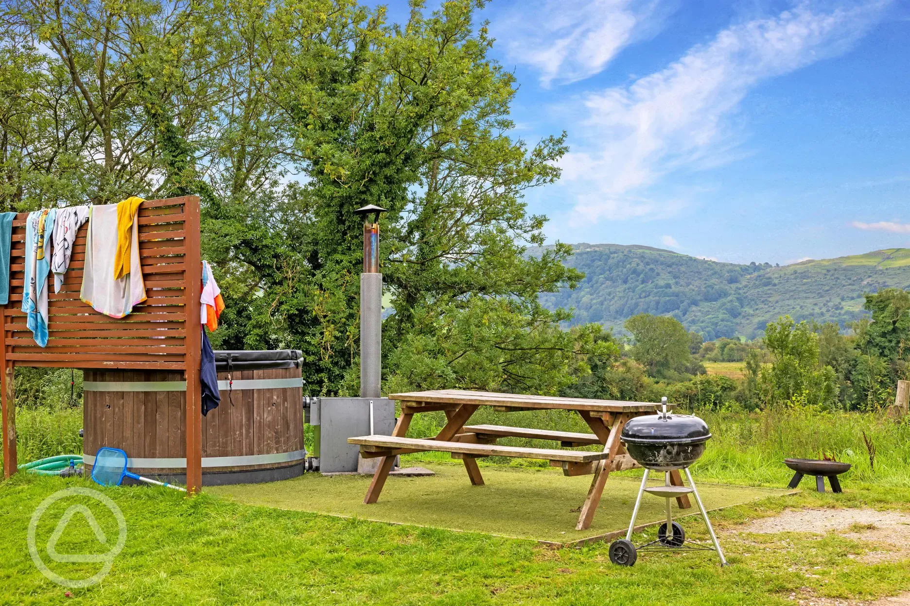 Yurt exterior with hot tub, outdoor seating, fire pit and BBQ