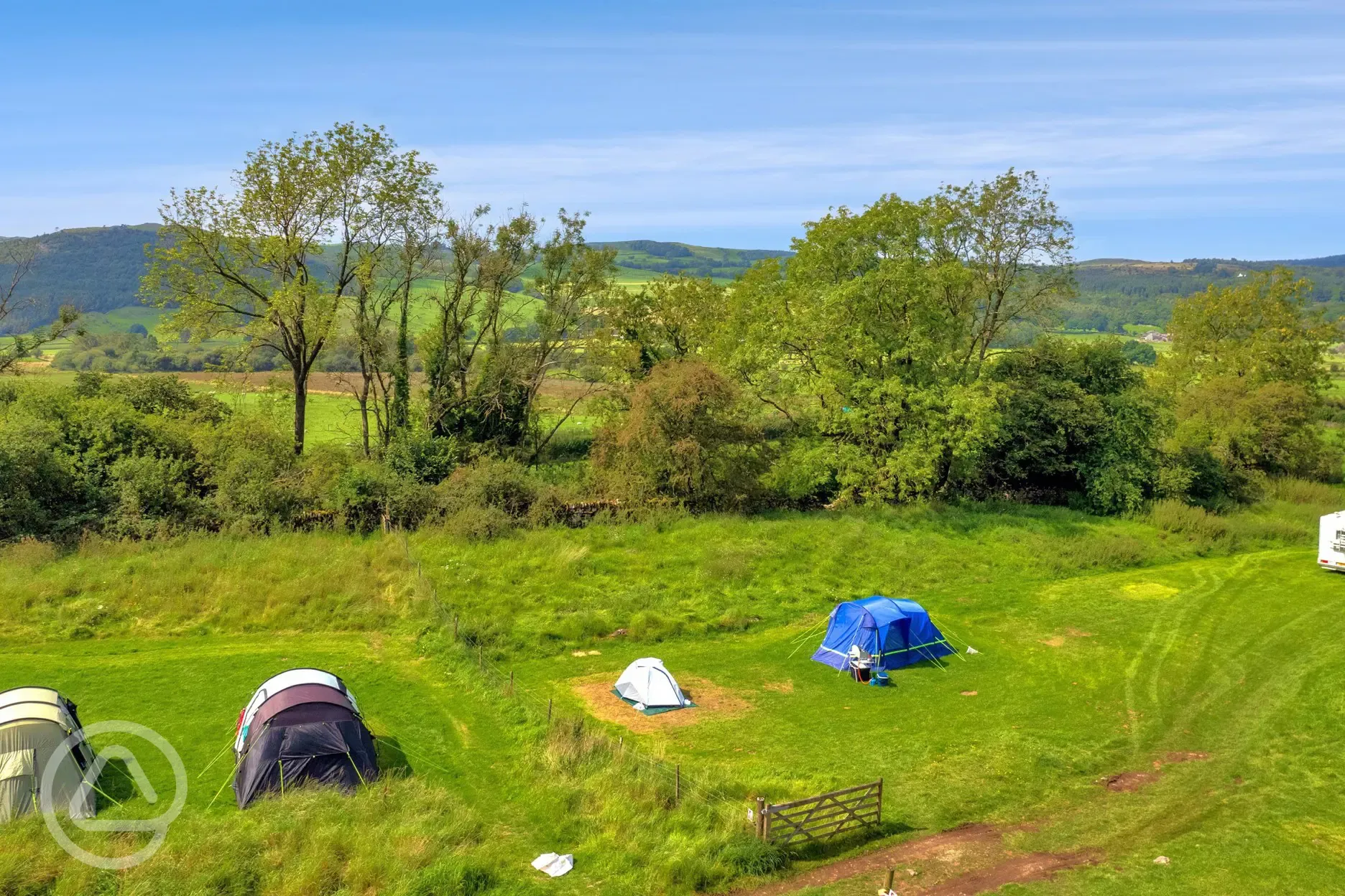 Grass pitches and surrounding countryside at yurts, mini lodge pods