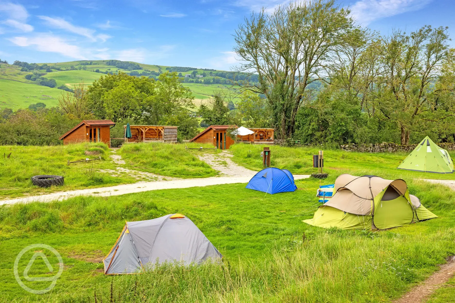 Grass pitches and mini lodge pods with countryside views