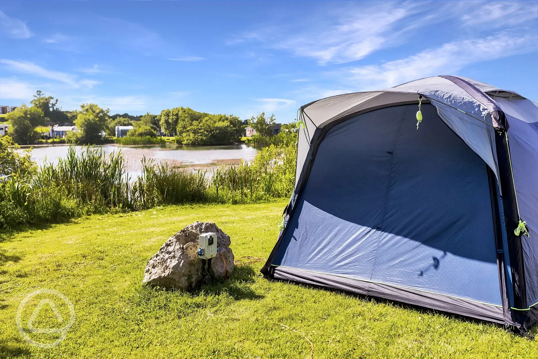 Tent on the electric grass pitches at Carn Springs next to the lake