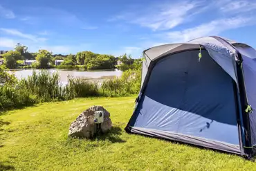 Tent on the electric grass pitches at Carn Springs next to the lake