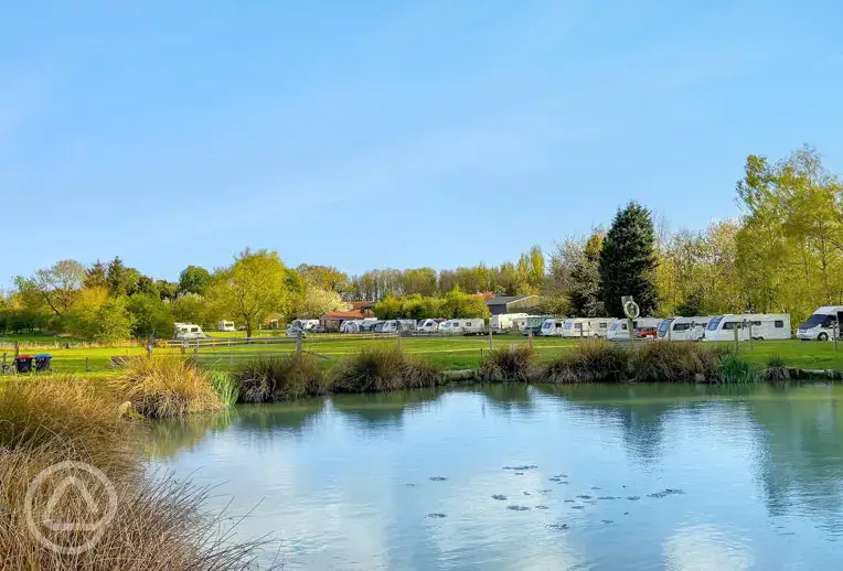 Pitches by the fishing pond at Little Owls Caravan and Camping