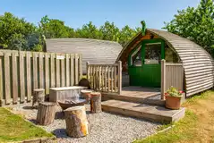 Bare Bones glamping pod with a gravel fire pit area and stool seats Bare Bones glamping pod with a gravel fire pit area and stool seats