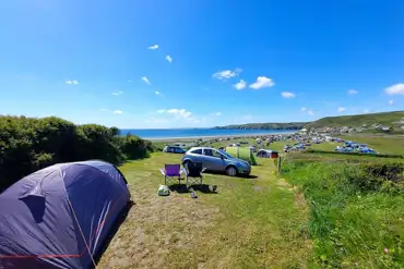 Unmarked non electric grass pitches at Newgale Campsite with space for a car