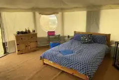 Yurt interior with a double bed and two bunk beds Yurt interior with a double bed and two bunk beds