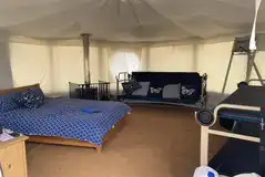 Yurt interior with a double bed and two bunk beds Yurt interior with a double bed and two bunk beds