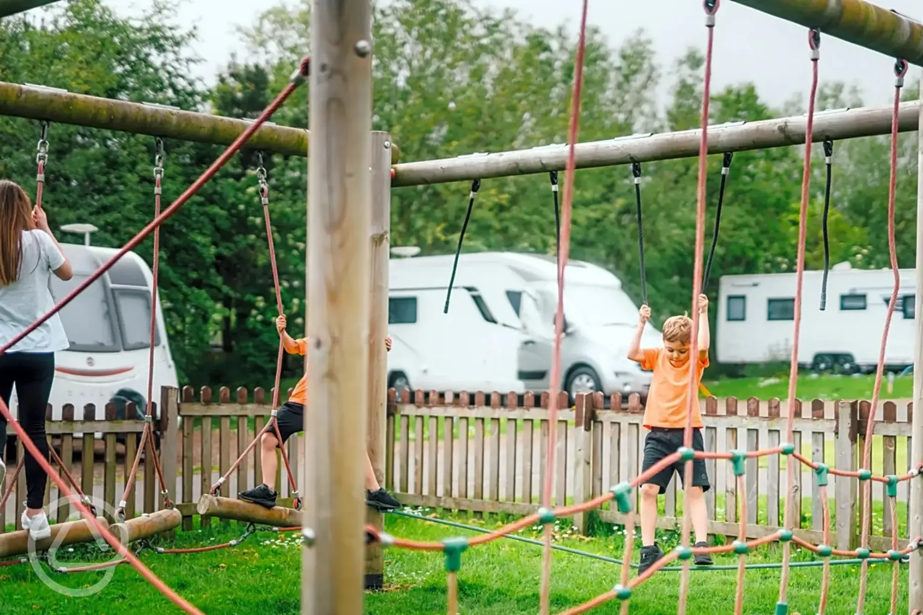 Climbing frame in the children's play area with tourers behind 