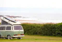 VW campervan on an electric grass touring pitch (5.5m x 9.5m)