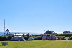 Electric grass tent pitches overlooking Croyde Bay