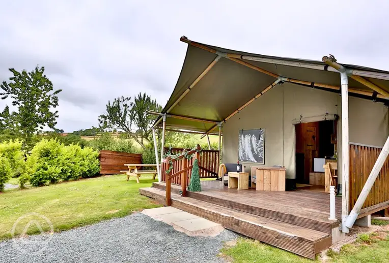 Safari tent with a deck area and outdoor furniture
