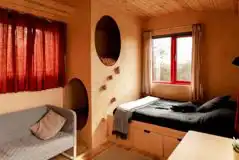 Allotment shepherd's hut interior with a double bed and sofa