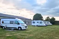Motorhome and caravans on the Robin electric grass pitches by farm buildings Motorhome and caravans on the Robin electric grass pitches by farm buildings