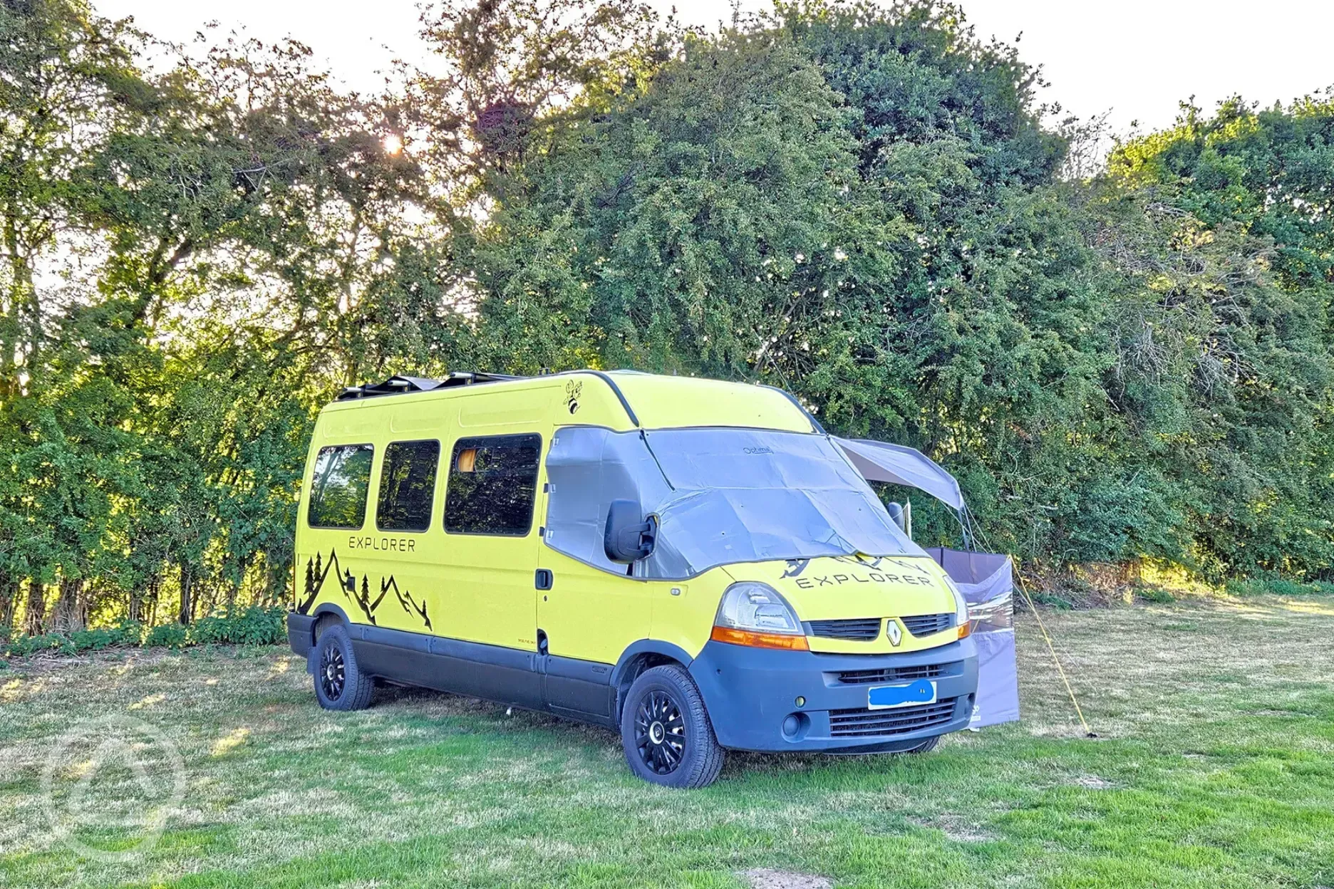 Campervan on a Rabbit non electric grass pitch backed by trees