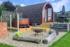 Ensuite glamping pods outdoor area with a fire pit, seating and hot tub