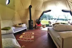Nature dome with a king sized bed, two single beds, and fire place