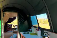 Nature dome kitchen with a sink, gas camping stove, and cool box