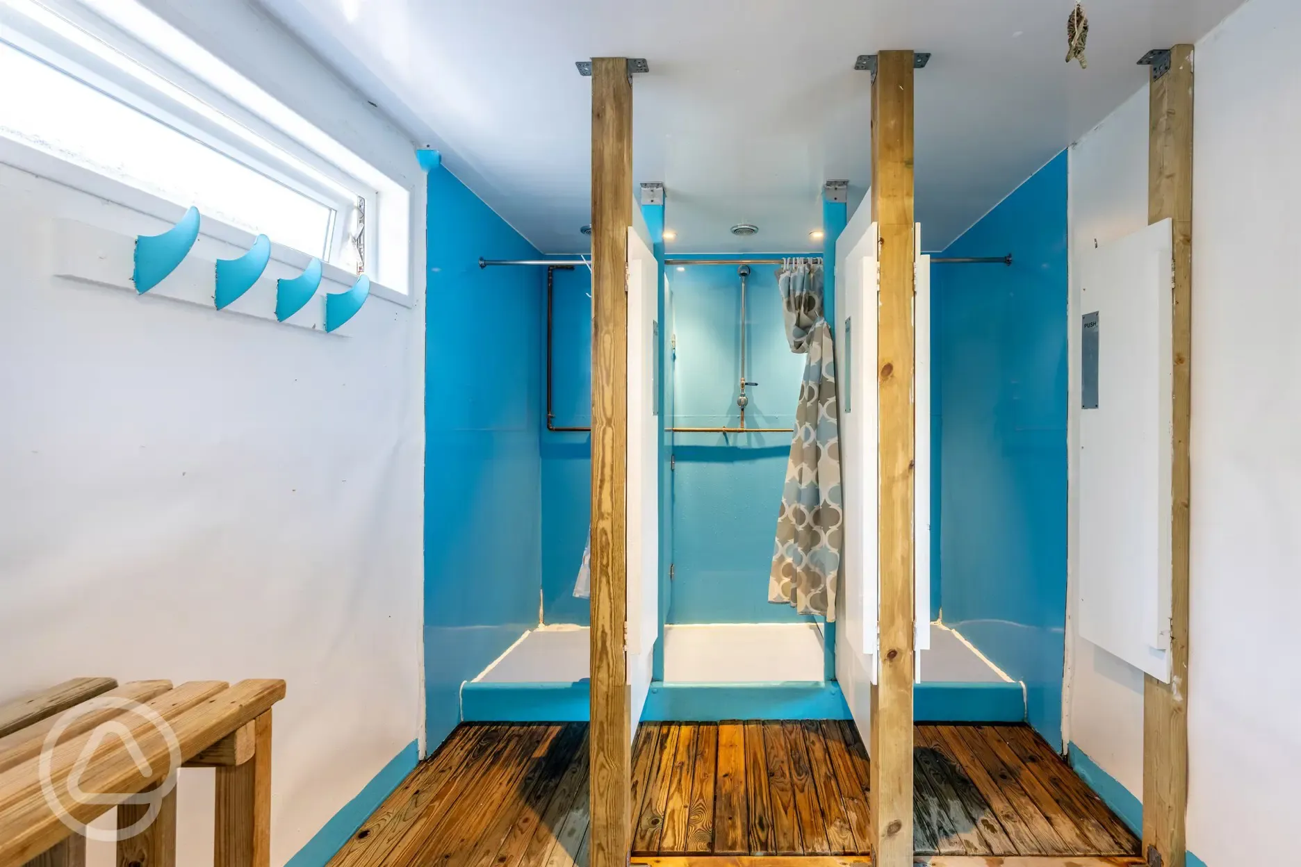 Showers with curtains, benches, and hooks