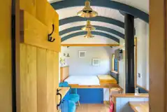 Ensuite shepherd's hut interior with double bed, kitchen and seating