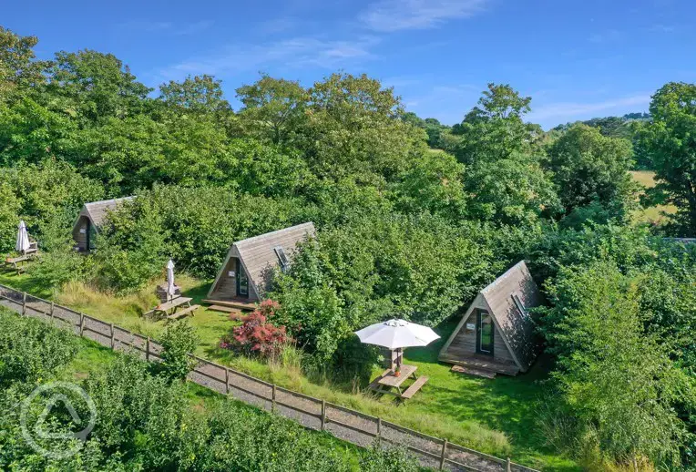 Converted chicken shed pods set amongst cob trees with outdoor seating