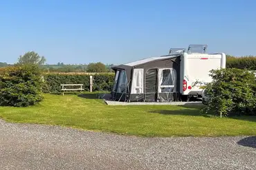Fully serviced premier pitches with picnic benches and hedging