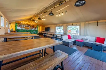 The Pearl and Oyster Bar in a safari tent with bench and sofa seating