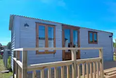 Shepherd's hut with a deck and outdoor table and chairs