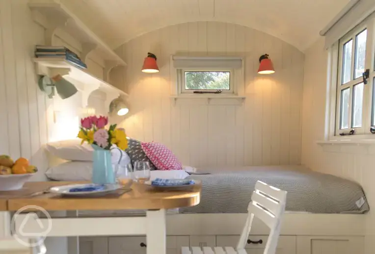 Shepherd's hut bed and dining area