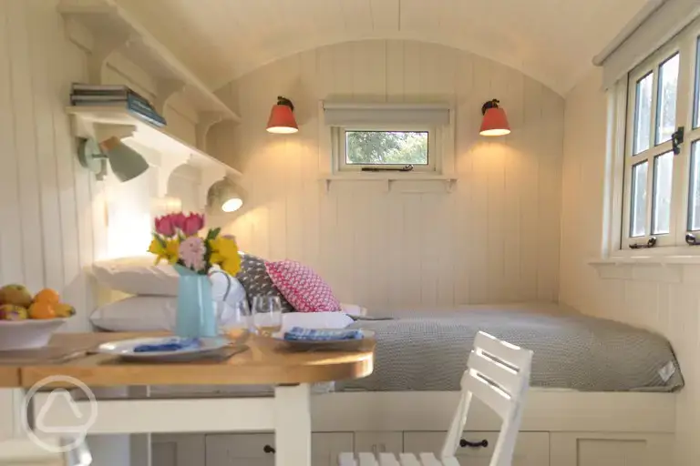 Shepherd's hut bed and dining area