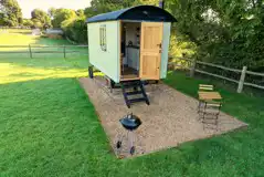 Shepherd's hut with an outdoor garden area, a BBQ, and fire pit