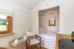 Shepherd's hut interior with a double bed (bedding and towels)