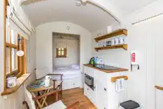 Shepherd's hut with a double bed, a micro kitchen, and furniture at Hale Farm 