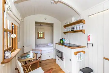 Shepherd's hut with a double bed, a micro kitchen, and furniture at Hale Farm 