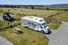 Electric hardstanding pitches with field and riverside views