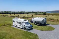 Electric hardstanding pitches with field and river views